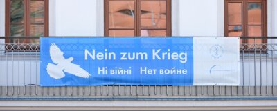 Ukraine: Freiberg sucht dringend Helfer - Das Friedensplakat am Balkon des Schlossplatzquartiers der TU Bergakademie Freiberg. Stadt und Universität zeichnen für mehrere Plakate mit der Losung im Stadtgebiet verantwortlich. 