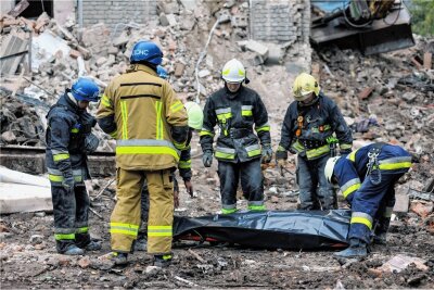 Ukraine-Krieg: Welchen Preis wollen wir zahlen? - Ukrainische Rettungskräfte bergen in Saporischschja einen Toten aus den Trümmern eines Hauses. Nach ukrainischen Angaben wurde es durch russische Raketen zerstört. 