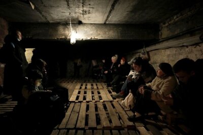 Menschen in Lwiw suchen in einem Keller Schutz vor Explosionen.