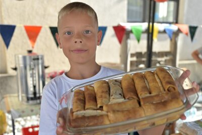 Ukrainer backen Kuchen für Spielplatzfest in Thalheim - Nikita Nesterenko, der Sohn von Maryna Nesterenko, aus Charkiw mit ukrainischem Gebäck.