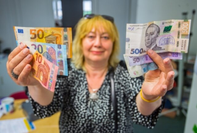 Tetjana Krykukha zeigt im Bürgerhaus Aue drei Euro- und Hrywnja-Scheine: Bislang war die ukrainische Währung nicht konvertibel. 