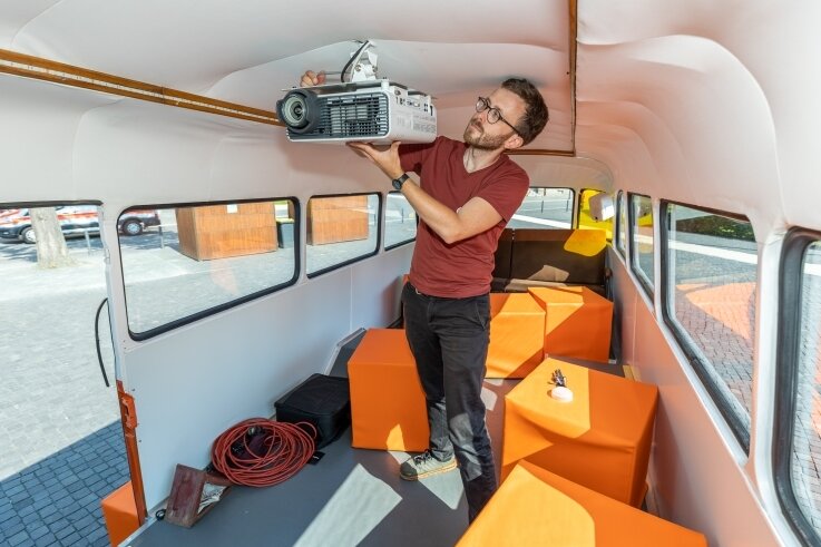 Umgebauter Kinobus startklar: Robur macht bei Inselfest Station - Matthias Ditscherlein montiert den Kurzdistanz-Projektor für die Filmvorführung. Je nach Bestuhlung finden bis zu 20 Personen im Bus Platz. Aber auch für draußen gibt es eine Leinwand. 