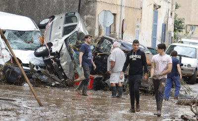 "Ums Überleben geschwommen": Tote und Chaos bei Unwetter auf Mallorca - In Sant Llorenc des Cardassar stapeln sich Autowracks in einer Straße.