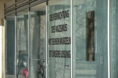 Umstrittenes Holocaust-Gedenken in Chemnitz beendet - Im Schaufenster eines Ladens im Bürohaus am Marx-Kopf ist eine Glassäule ausgestellt, die offenbar auch Asche von Holocaust-Opfern enthält. Nebenan ist ein Teil des sogenannten Schwures von Buchenwald zu lesen. 