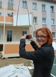 Umzug ist jetzt kein Thema mehr - 
              <p class="artikelinhalt">Silvia Mühlberg hält den Balkonanbau im Bild fest.  </p>
            