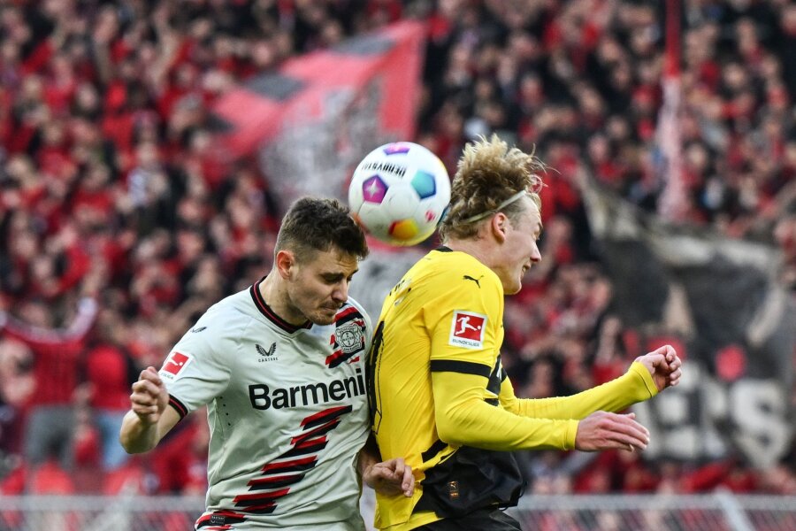 Unbesiegbarkeit als Mission: Leverkusen und die späten Tore - Leverkusens Josip Stanisic und Dortmunds Julian Brandt kämpfen um den Ball.