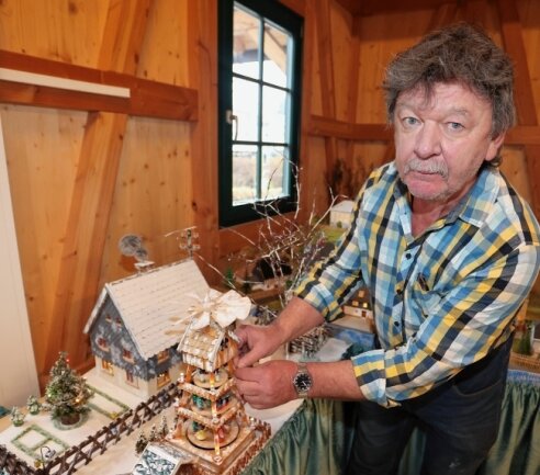 Unternehmer erfüllt sich Museumstraum - Uwe Steglich platziert die Ortspyramide auf dem als Weihnachtsberg nachgestalteten Dorf.