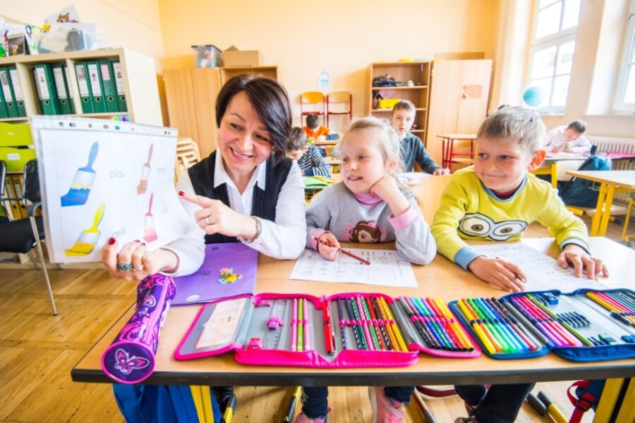 In der Grundschule Bernsbach unterrichtet Elena Bueva die Kinder aus der Ukraine. Neben ihr sitzen Sofia Gerashchenko und Maxim Polischyk. 