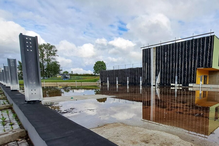 Unvollendetes Grundschulprojekt in Grünhainichen: Wie es mit dem Turnhallenanbau weitergeht - Nach starkem Regen gleicht die Bodenplatte der neuen Turnhalle an der Grünhainichener Grundschule einem Schwimmbecken.
