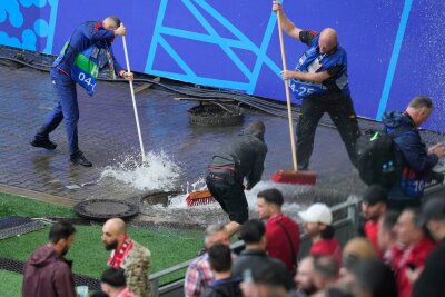 Unwetter in Teilen Deutschlands - Fanzonen betroffen - Kampf gegen die Wassermassen: Mitarbeiter sind vor dem Spiel Türkei gegen Georgien im Stadion im Einsatz.