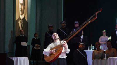 Elmar Hauser als Hanno Buddenbrook in der Oper "Buddenbrook" in Kiel spielt auf seiner Theorbe.