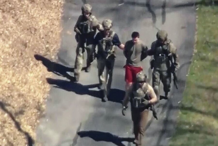 US-Leak: Der Staatsfeind in roter Sporthose - Dieses Bild aus einem von WCVB-TV zur Verfügung gestellten Video zeigt Jack Teixeira in T-Shirt und Shorts, der von bewaffneten Einsatzkräften in Gewahrsam genommen wird. 