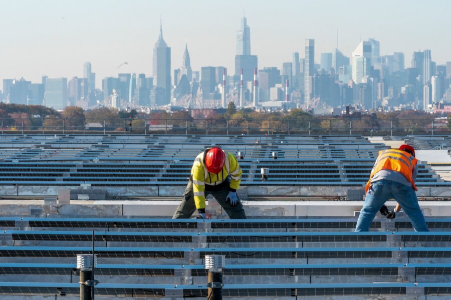 USA beenden Zoll-Befreiung für manche Solar-Importe - Elektriker installieren im New Yorker Stadtteil Queens Solarpaneele. Die US-Regierung hebt Zoll-Ausnahmen für bestimmte Solar-Importe auf.