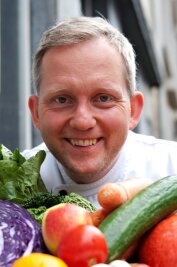 Veganer Koch: «Wir können jeden überzeugen» - Robert Beck, Koch im vegetarischen Restaurant "Hiller", sitzt im September 2012 in Hannover an einem Tisch voll Gemüse vor dem Restaurant.