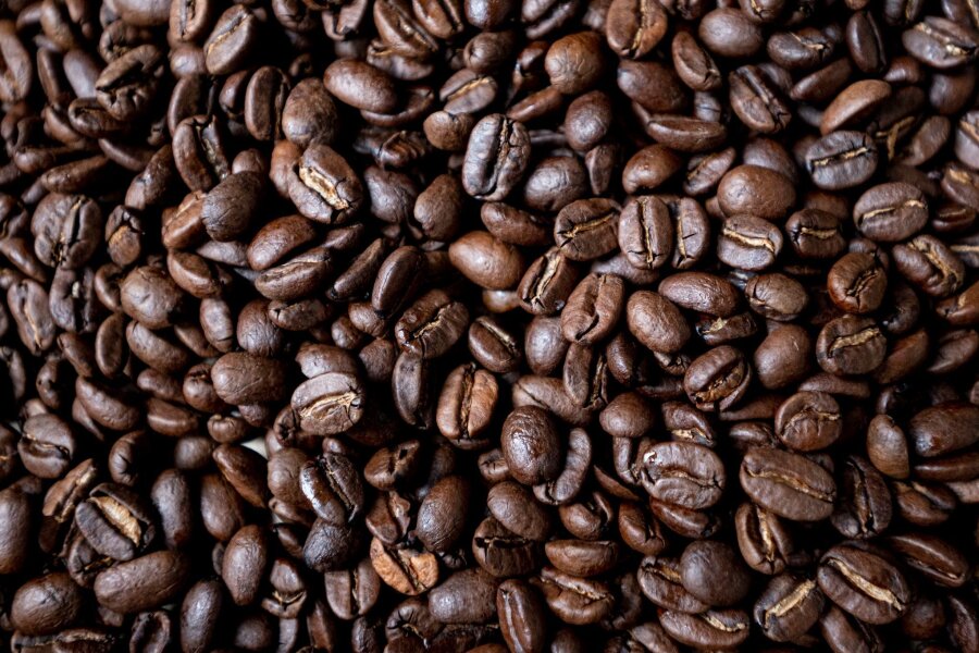 Verband befürchtet möglichen Kaffeemangel ab 2025 - Geröstete Kaffeebohnen liegen auf einem Tisch. In der Woche vor Weihnachten senkt Aldi die Preise für Kaffee deutlich. Edeka, Rewe, Penny, Netto und Norma kündigten an, dem Beispiel zu folgen.