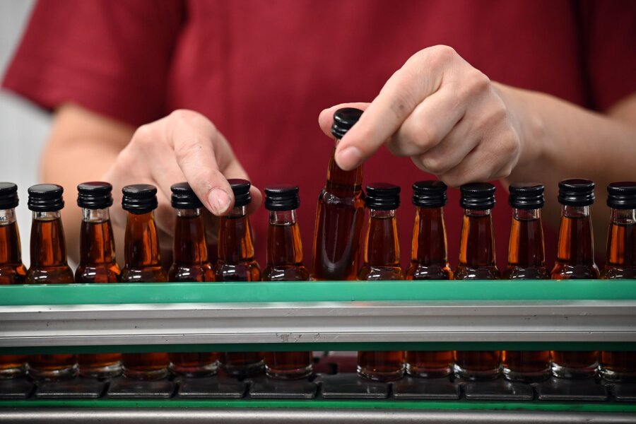 Verbraucher kaufen weniger Spirituosen - Eine Mitarbeiterin eines Spirituosenherstellers kontrolliert die abgefüllten Flaschen. Die Zurückhaltung beim Konsum macht sich auch bei den Spirituosen-Herstellern bemerkbar (Symbolbild).
