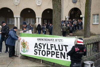 Görlitz im April dieses Jahres: Teilnehmer einer Kundgebung der rechtsextremen Kleinstpartei Freie Sachsen halten vor dem Beruflichen Schulzentrum einen Banner mit der Aufschrift "Asylflut Stoppen".