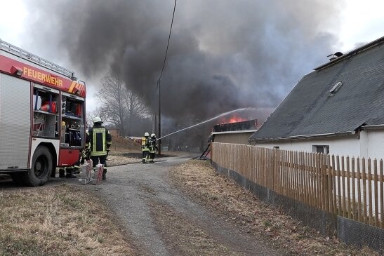 Verheerender Brand: Wehr rettet Wohnhaus in Trieb - Das Wohnhaus (rechts) konnte mit Mühe vor den Flammen gerettet werden. Durch die Hitze war ein Fenster bereits geborsten.