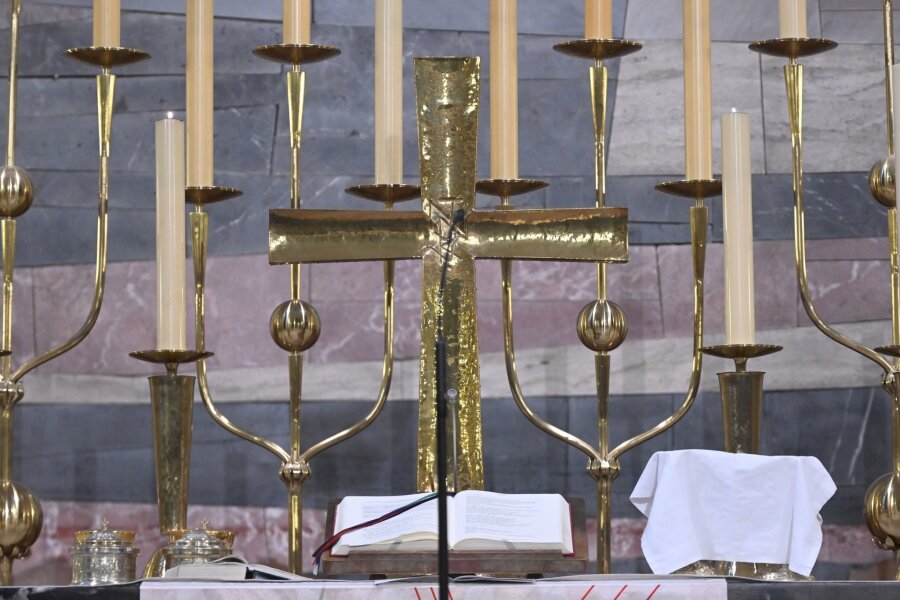 Vertraute Seelsorge im Urlaub: Sächsische Pfarrer auf Reisen - Ein Kreuz ist vor einem evangelischen Festgottesdienst in einer Kirche zu sehen.