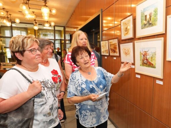 Maria Ludwig schaut sich mit ihren Kursteilnehmerinnen die Ausstellung in der Kleinen Galerie an.