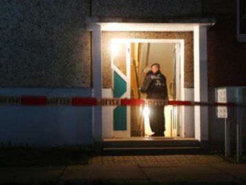 Vier Tote in Wohnung in Jena - wahrscheinlich Beziehungsdrama  - Polizeibeamte stehen im Eingang eines Wohnhaus. Hier wurden vier Leichen gefunden.