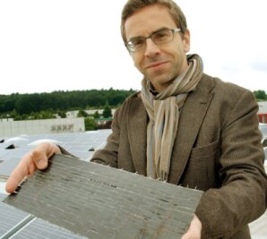 Vogtländer entwickeln Schnee-Frühwarnsystem - Schnee-Fachmann Andreas Meybohm zeigt den Sensor im Kohlefasergewebe, der fast so aussieht wie die Fotovoltaikanlage im Hintergrund. Der Sensor wird jedoch nicht auf, sondern unter dem Dach angebracht.