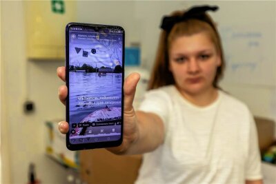 „Vogtland hilft“ am Start: Anastasiia bittet um Hilfsgüter für Flutopfer in Cherson - Anastasiia Shevliakova zeigt auf ihrem Smartphone Bilder von der Flutkatastrophe am Staudamm nahe ihrer Heimatstadt Cherson. Dorthin hat sie Kontakte, die sie für die Spendensammlung nutzt.