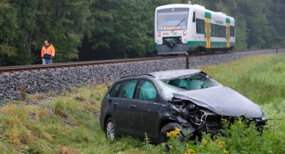 Vogtlandbahn kollidiert mit Auto - Fahrer schwerverletzt -              Zirka 20 Meter wurde der VW Golf Kombi vom Regio-Shuttle der Vogtlandbahn nach der Kollision auf dem Bahnübergang mitgeschleift, ehe er die Böschung herunterrutschte.            