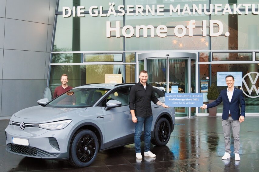 Volkswagen Sachsen: Gläserne Manufaktur in Dresden schafft Auslieferungsrekord - Rekord-Abholung: VW-Produktexperte Robert Pardavi (r.) mit Stefan Beer (m.) aus Bayern, der mit seinem Schwiegervater angereist ist, am ID.4.