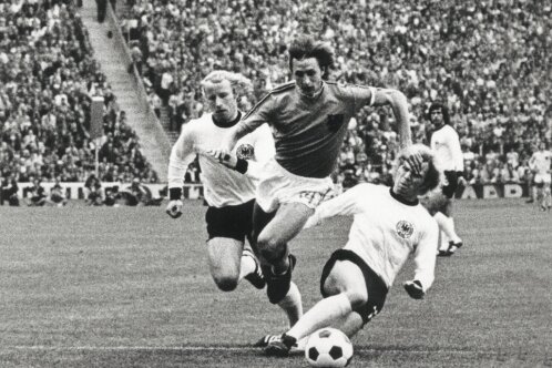 Vom Schuhputzer zum Weltstar - Johan Cruyff wird im WM-Finale 1974 von Uli Hoeneß und Berti Vogts (links) in die Zange genommen.