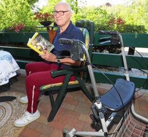 Von einem Dynamo und seinem unglaublich verrückten Leben - Siegfried Walther in seinem Gartenstuhl mit einem Buch über Dynamo Dresden. 