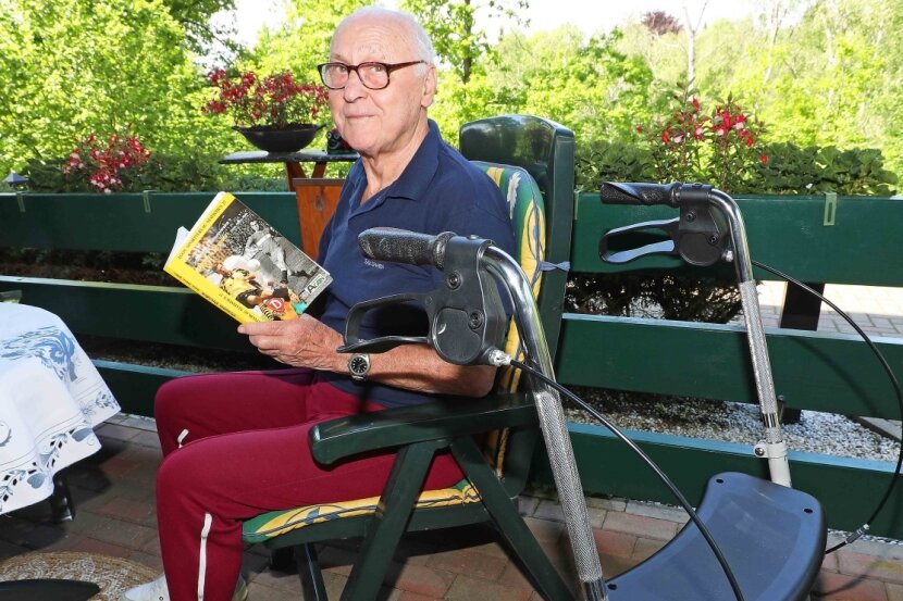 Von einem Dynamo und seinem unglaublich verrückten Leben - Siegfried Walther in seinem Gartenstuhl mit einem Buch über Dynamo Dresden. 