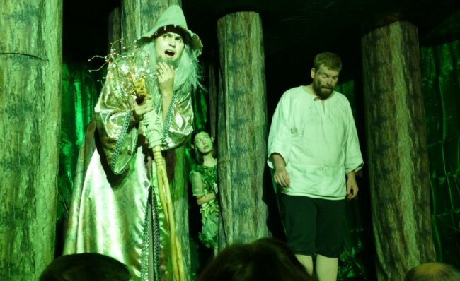 Von Waldgeistern und reichen Holzfällern - Das Glasmännlein (links), gespielt von Henry Merbeth, warnt Peter, gespielt von Philipp Wenzel, davor, zu gierig zu werden. Ein Waldgeist beobachtet die Szene. 