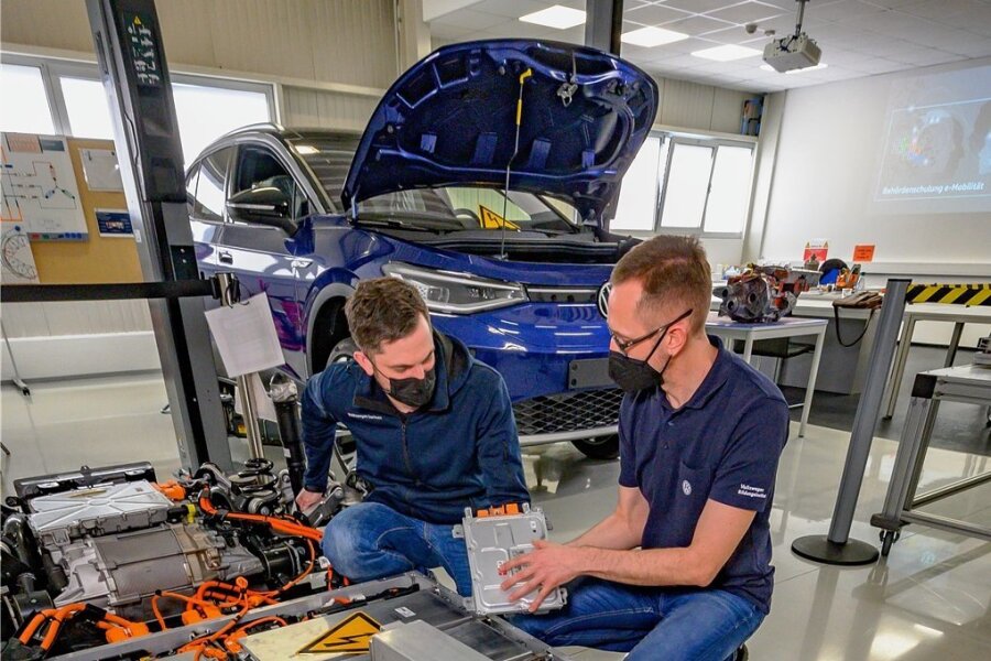 Hochvoltexperte Dirk Lorenz (rechts) erklärt Tobias Müller einen Teil der Batterietechnik in einem Elektroauto.