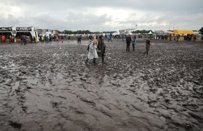 Wacken: Metal-Fans sind auf dem schlammigen Festivalgelände unterwegs.