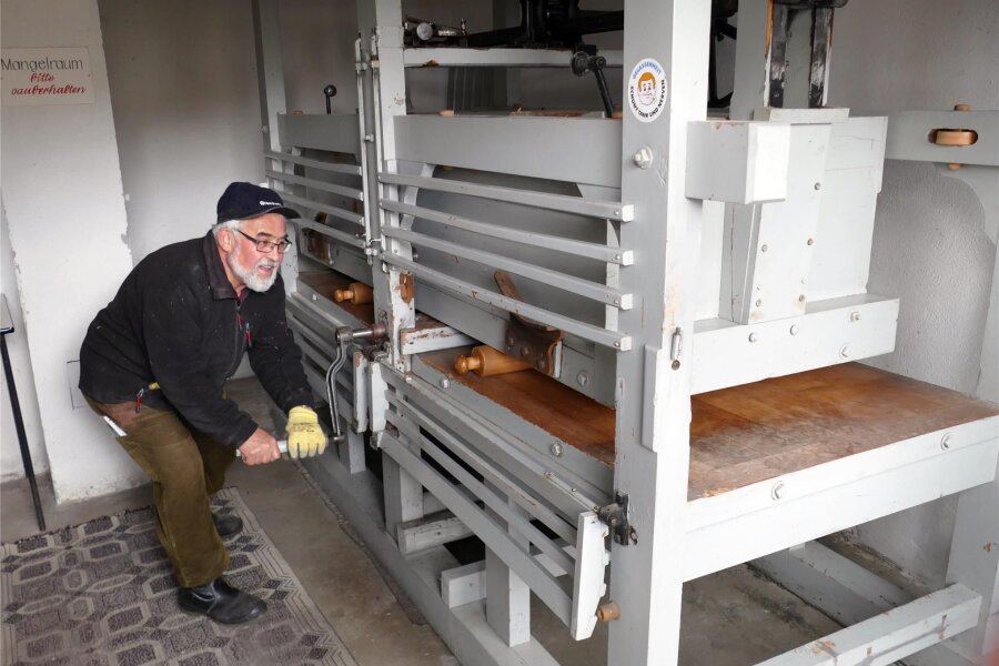 Wäsche mangeln wie vor 100 Jahren: Wie das Gelenauer Strumpfmuseum eine Tradition bewahrt - Hier bedient Thomas Börner die rund 100 Jahre alte Wäschemangel per Hand. Dafür gibt es auch einen Motor, doch der wurde bereits für den Transport abmontiert.
