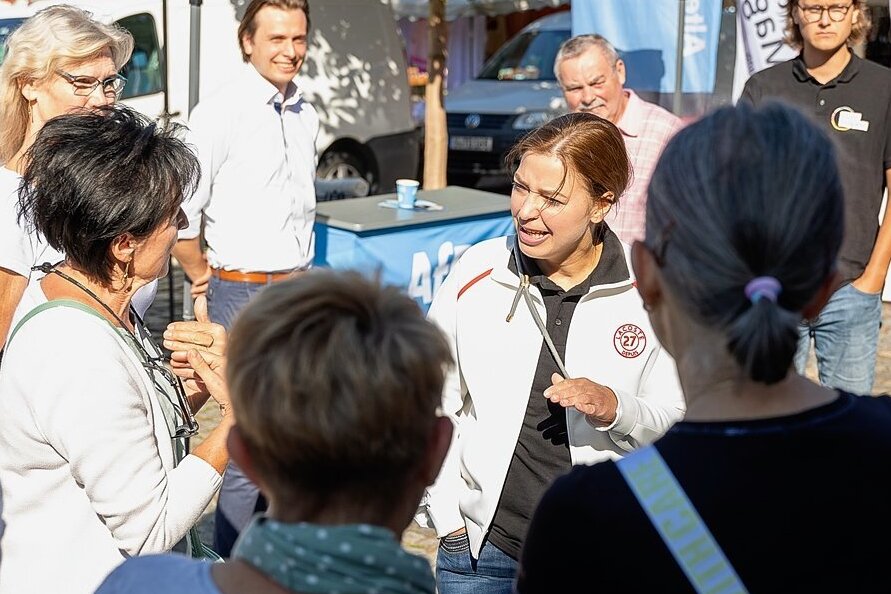 Frust ablassen bei Yvonne Magwas: Die CDU-Bundestagsabgeordnete diskutiert auf dem Auerbacher Wochenmarkt mit einer Gruppe von Coronakritikern. Im Hintergrund AfD-Kandidat Mathias Weiser.