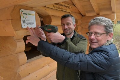 Wander-Schutzhütten im Erzgebirge zieren jetzt Gütesiegel für einheimisches Holz - Clemens Weiser vom Forstbezirk (li.) und Philipp Strohmeier von „Holz von hier“ bringen das Gütesiegel an.