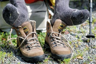 Wanderfreunde zwischen Schwarzwasser- und Pöhlwassertal unterwegs - Ein Wanderer hat seine Schuhe ausgezogen, um die Füße nach einer Wanderung zu lüften. 