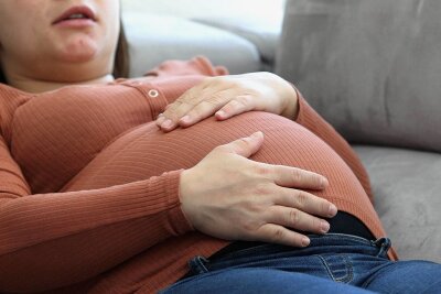 Wann Gähnen besonders ansteckend ist - Eine schwangere Frau, die sich hingelegt hat. Doch macht Schwangerschaft wirklich müde? 