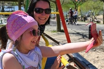 Warmes Wetter lockt in Sonnenlandpark - Die sechsjährige Emma Kelimes mit ihrer Mutter Andrea beim gemeinsamen Foto auf der Schaukel im Sonnenlandpark.