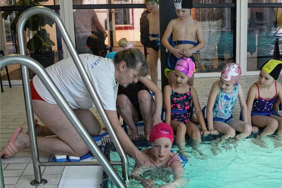 Wartezeiten bis zu einem Jahr: Wo Eltern im Vogtland jetzt noch schnell einen Schwimmkurs fürs Kind finden - Petra Hoffmann von der Wasserwacht Brunn gibt Lina Hilfestellung beim ersten Versuch mit einer Schwimmhilfe. Die Kurse im Bad der früheren BG-Klinik Dorfstadt sind rappelvoll. Wartezeit: ein Jahr. 
