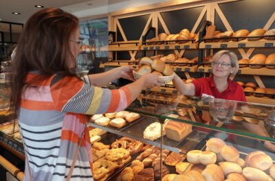 Warum Bäckereien die Preise anheben - Kundin Katja Borchardt kauft im sogenannten Genussplatz der Mühlenbäckerei Clauß in Zwickau bei Fachverkäuferin Sylvia Hausotto Doppelbrötchen für 70 Cent pro Stück. 