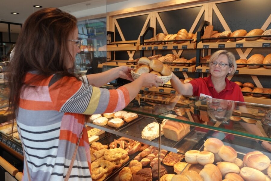Kundin Katja Borchardt kauft im sogenannten Genussplatz der Mühlenbäckerei Clauß in Zwickau bei Fachverkäuferin Sylvia Hausotto Doppelbrötchen für 70 Cent pro Stück. 