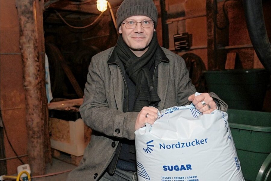 Warum das Oelsnitzer Bergbaumuseum Unmengen an Zucker verbraucht - Matthias Hempel mit einem der 25-Kilogramm-Säcke Zucker, die das Museum über den Großhandel erwirbt. Hinten links ist die Wanne zu sehen, in der das Huntgestell in der Zuckerlösung liegt. 