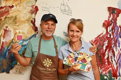 Warum das Schokoladen-Festival 2024 auf der Rochsburg ausfällt – und 2025 in Chemnitz groß gefeiert wird - Peggy und Patrick Walter in den Manufakturräumen von Choco Del Sol in Burgstädt. Ein Künstler hat eine Wand mit den Umrissen der Herkunftsländer der Kakaobohnen gestaltet. Davon leiten sich die Verpackungen ab.