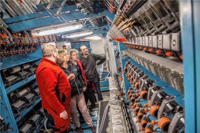 Warum die Firma Otex in Flöha eine Texturiermaschine und eine Tischtennisplatte in Betrieb nimmt - Robert Wobst (vorn), Teamleiter Mechanik und Instandhaltung, erläutert den Kolleginnen und Kollegen die neue Texturiermaschine, die zurzeit noch im Probebetrieb läuft. 