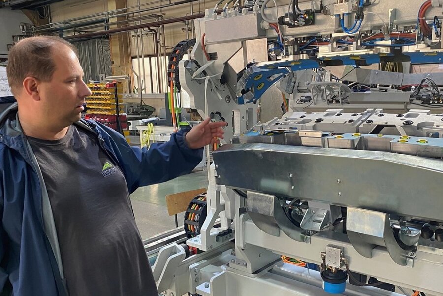 André Karbstein, Inhaber des Klingenthaler Maschinenherstellers KMW Engineering, an einer in dem Unternehmen entwickelten und produzierten Klebemaschine, mit der Heckspoiler von Autos hergestellt werden. 