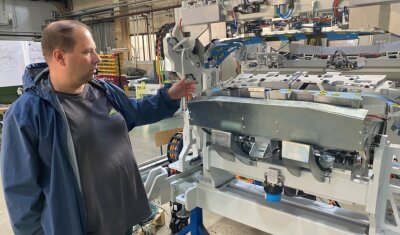 Warum ein Maschinenhersteller nicht weiter wachsen soll - André Karbstein, Inhaber des Klingenthaler Maschinenherstellers KMW Engineering, an einer in dem Unternehmen entwickelten und produzierten Klebemaschine, mit der Heckspoiler von Autos hergestellt werden. 