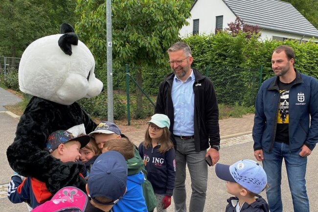 Heißgeliebter Panda: Kinder aus der Kita Böhrigen bestürmen das WWF-Wappentier. Edeka-Betriebsleiter Stephan Kleyer (M.) und Ortsvorsteher Philipp Resch freuen sich über die gelungene Aktion.